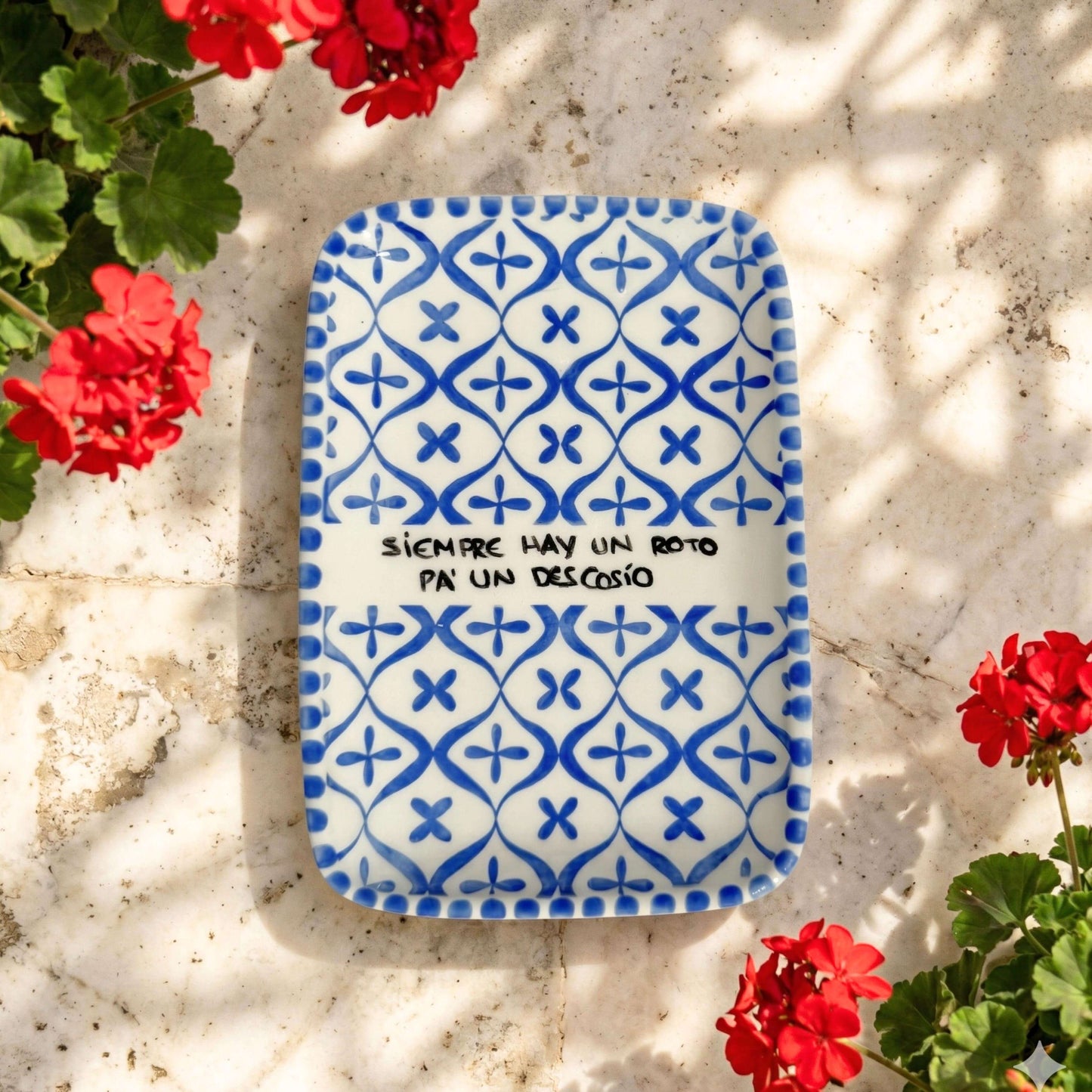 Bandeja de cerámica Un Roto pa un Descosio sobre patio andaluz en ambiente decorativo Kinara.