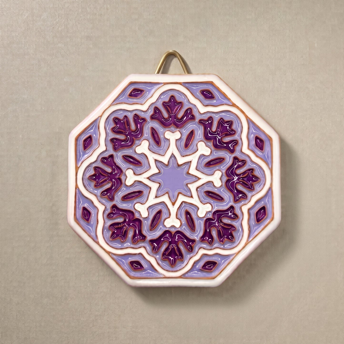 Vista frontal completa del plato decorativo de pared octagonal en relieve Estrella Amatista, pintado a mano con geometría andalusí en tonos lila, violeta, blanco y detalles en bronce Kinara.