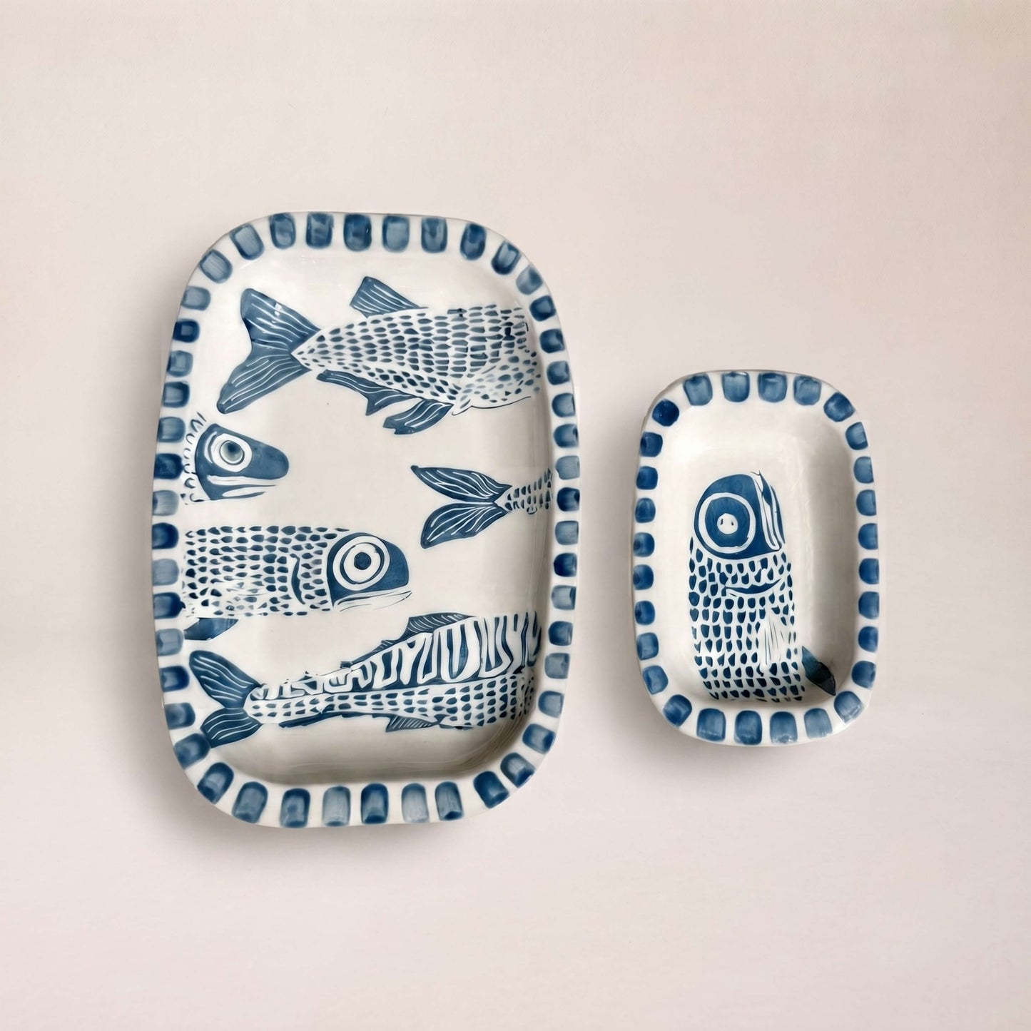 Conjunto La Caleta de dos bandejas de cerámica artesanal pintadas a mano con peces en azul cobalto Kinara.